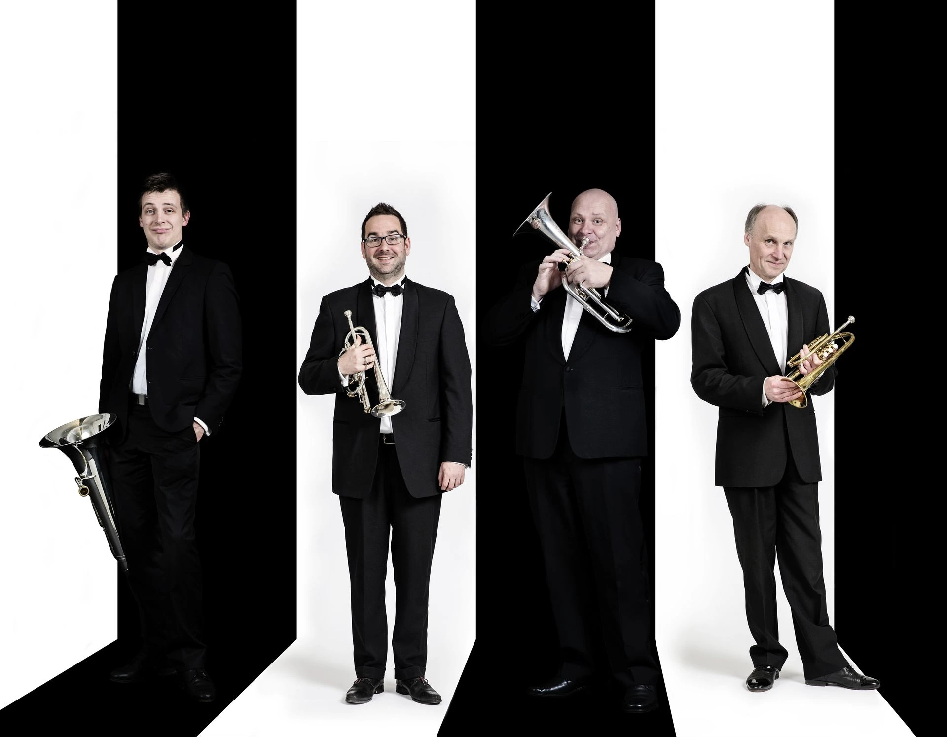 Vier topmuzikanten voor een wit/zwarte achtergrond, elk met hun geliefde instrument in de hand. Guy Godts 
