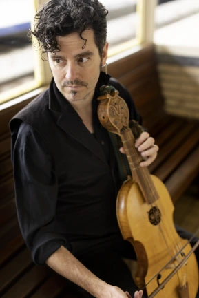 Thomas Baeté staart voor zich uit met zijn viola de gamba in de hand